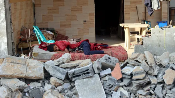Pierre Stambul sur France-Culture. Un garçon palestinien dort dans les ruines de sa maison familiale détruite lors des frappes aériennes israéliennes sur la ville de Gaza (2021) ©AFP - MOHAMMED ABED / AFP