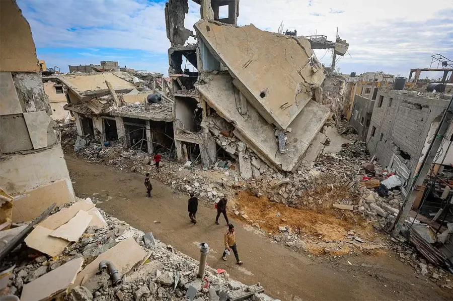 Assassinats de masse : les bombardements calculés d'Israël sur Gaza — Des Palestiniens marchent à côté des décombres de bâtiments détruits par des frappes aériennes israéliennes à Khan Younis, dans le sud de la bande de Gaza, le 28 novembre 2023. (Atia Mohammed/Flash90)