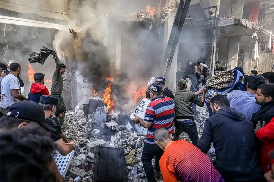 Assassinats de masse : les bombardements calculés d'Israël sur Gaza — Des Palestiniens tentent d'éteindre un incendie après une frappe aérienne israélienne sur une maison dans le camp de réfugiés de Shaboura dans la ville de Rafah, au sud 