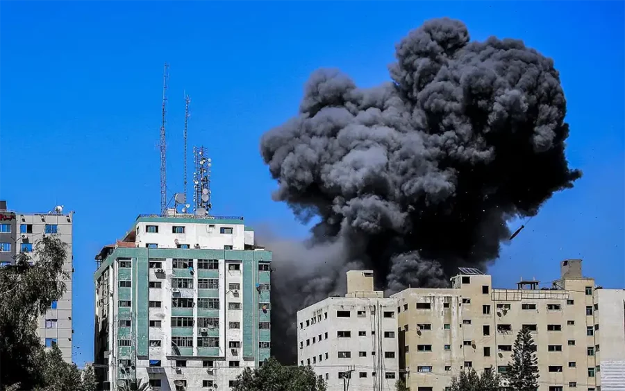 Assassinats de masse : les bombardements calculés d'Israël sur Gaza — De la fumée s'élève après qu'une frappe aérienne israélienne ait touché la tour Al-Jalaa, qui abrite des appartements et plusieurs médias, dont l'Associated Press et Al Jazeera, dans la ville de Gaza, le 15 mai 2021. (Atia Mohammed/Flash90)