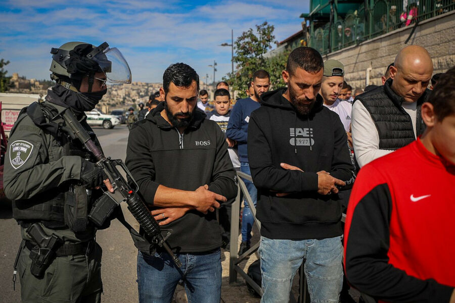 La police israélienne monte la garde pendant que les Palestiniens font la prière du vendredi dans le quartier occupé de Ras Al Amud à Jérusalem-Est, le 8 décembre 2023. (Jamal Awad/Flash90)