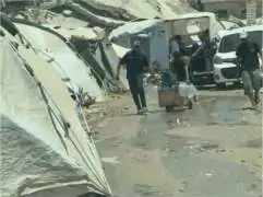Photo les gens transportent de l'eau potable sur un site de déplacement dans le centre de Gaza.