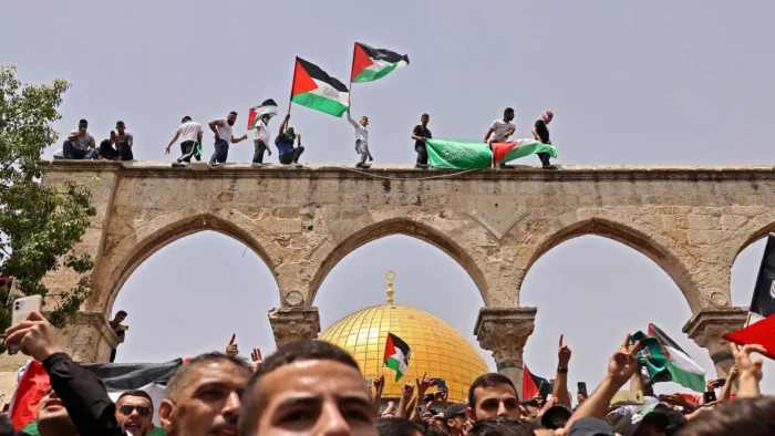 Jérusalem, 21 mai 2021. Le drapeau palestinien et celui du Hamas brandis lors d’affrontements avec les forces de sécurité israéliennes dans l’enceinte de la mosquée Al-Aqsa Ahmad Gharabli/AFP