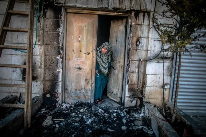 Une Palestinienne examine lexterieur de sa porte incendie par des colons juifs a Huwwara en Palestine occupee le 26 fevrier 2023 jpg Les appels israéliens au génocide accueillis dans l’indifférence générale à Washington et à Bruxelles