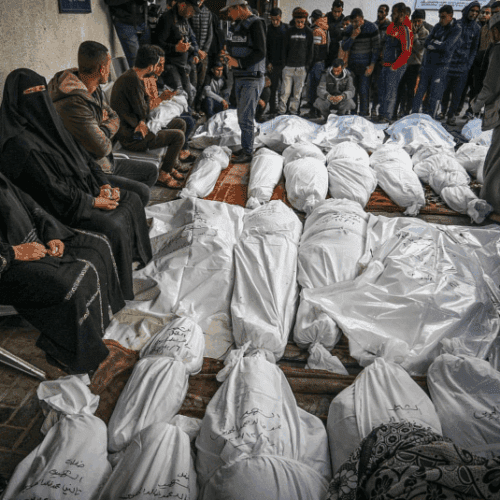 Des Palestiniens attendent de recevoir les corps de leurs proches qui ont été tués lors d'une frappe aérienne israélienne, à l'hôpital Al-Najjar, dans le sud de la bande de Gaza, le 7 décembre 2023. (Abed Rahim Khatib/Flash90)