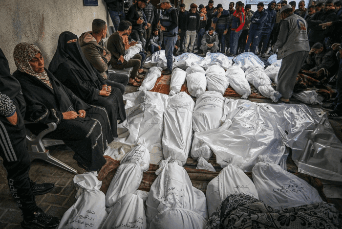 Des Palestiniens attendent de recevoir les corps de leurs proches qui ont été tués lors d'une frappe aérienne israélienne, à l'hôpital Al-Najjar, dans le sud de la bande de Gaza, le 7 décembre 2023. (Abed Rahim Khatib/Flash90)