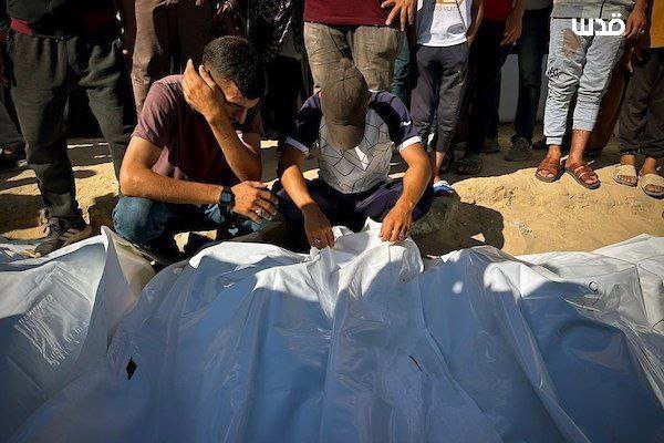 Photo Témoignage Abu Amir Gaza 9 juillet 2025 - 2 hommes inspectent des corps sous une bache plastique