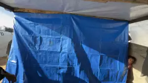 Témoignage d'Abu Amir, le 15 décembre 2025 - Gaza entre le feu des raids et le froid de l’hiver 14 Un enfant derriere une bache bleue